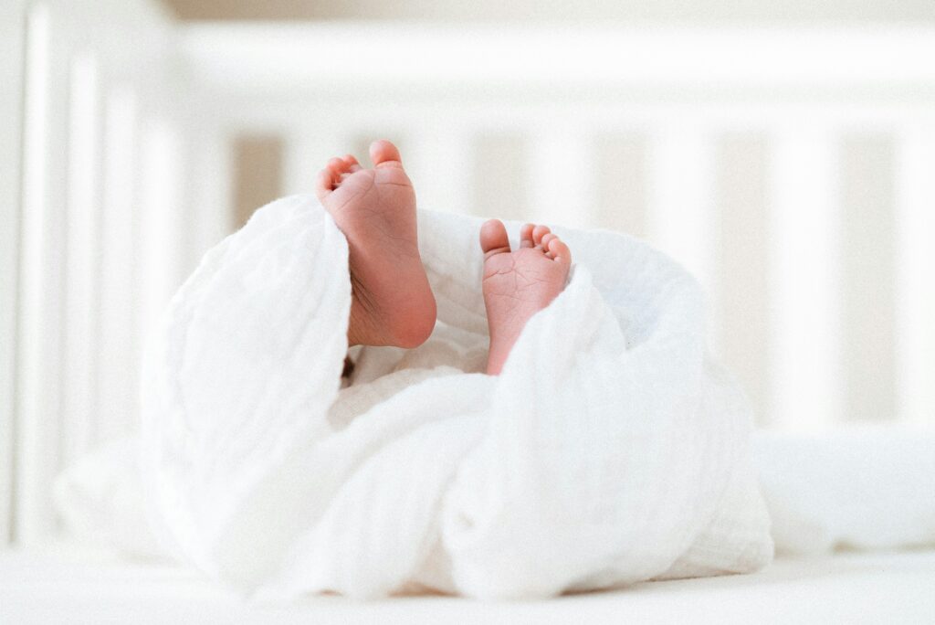 newborn baby feet in white blanket