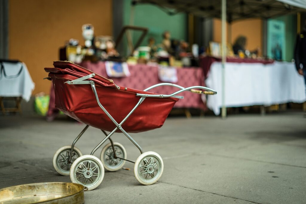 vintage red stroller vacant on a sidewalk